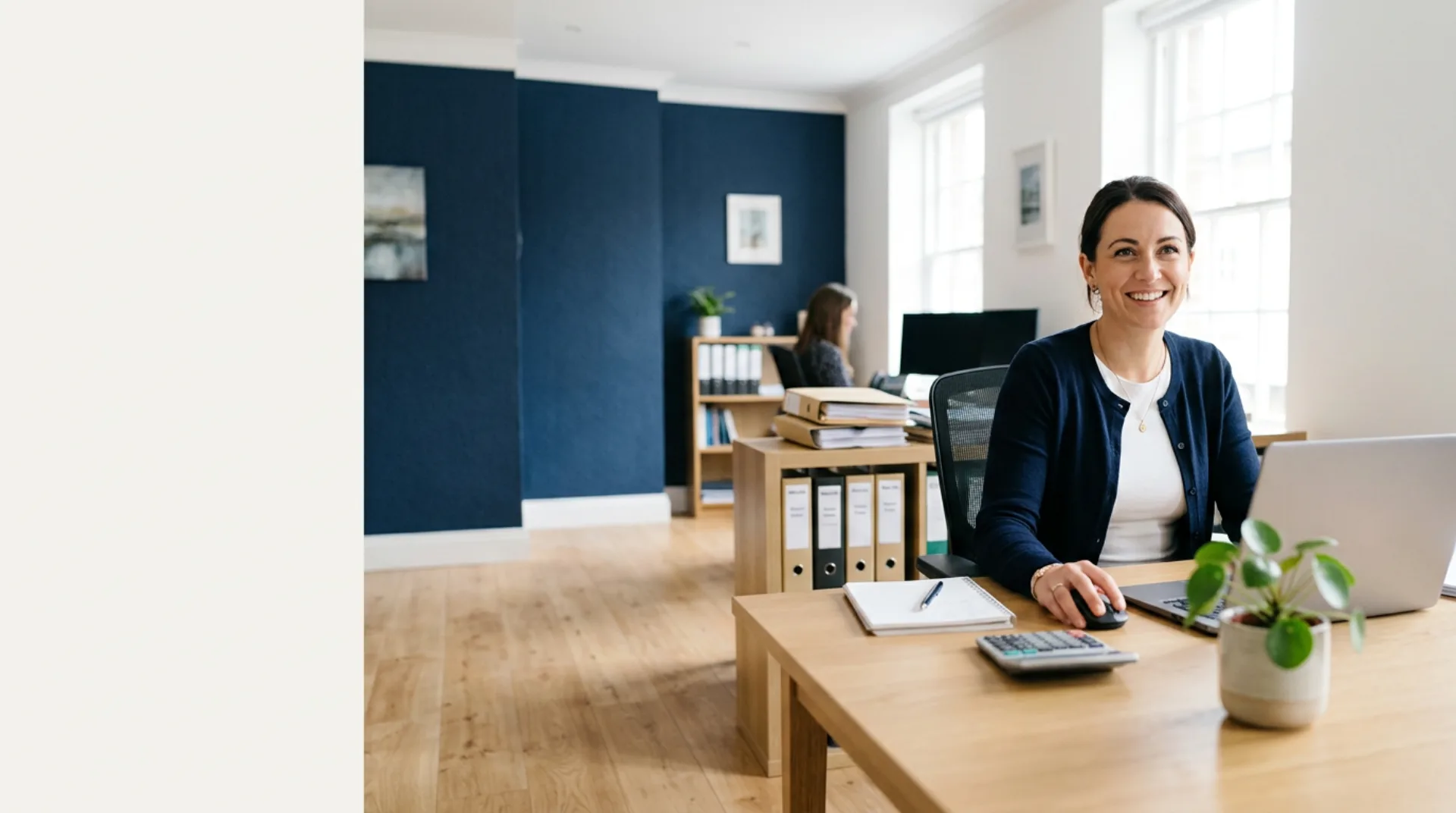 A modern UK accountancy practice, accountant at a desk with a laptop and client files
